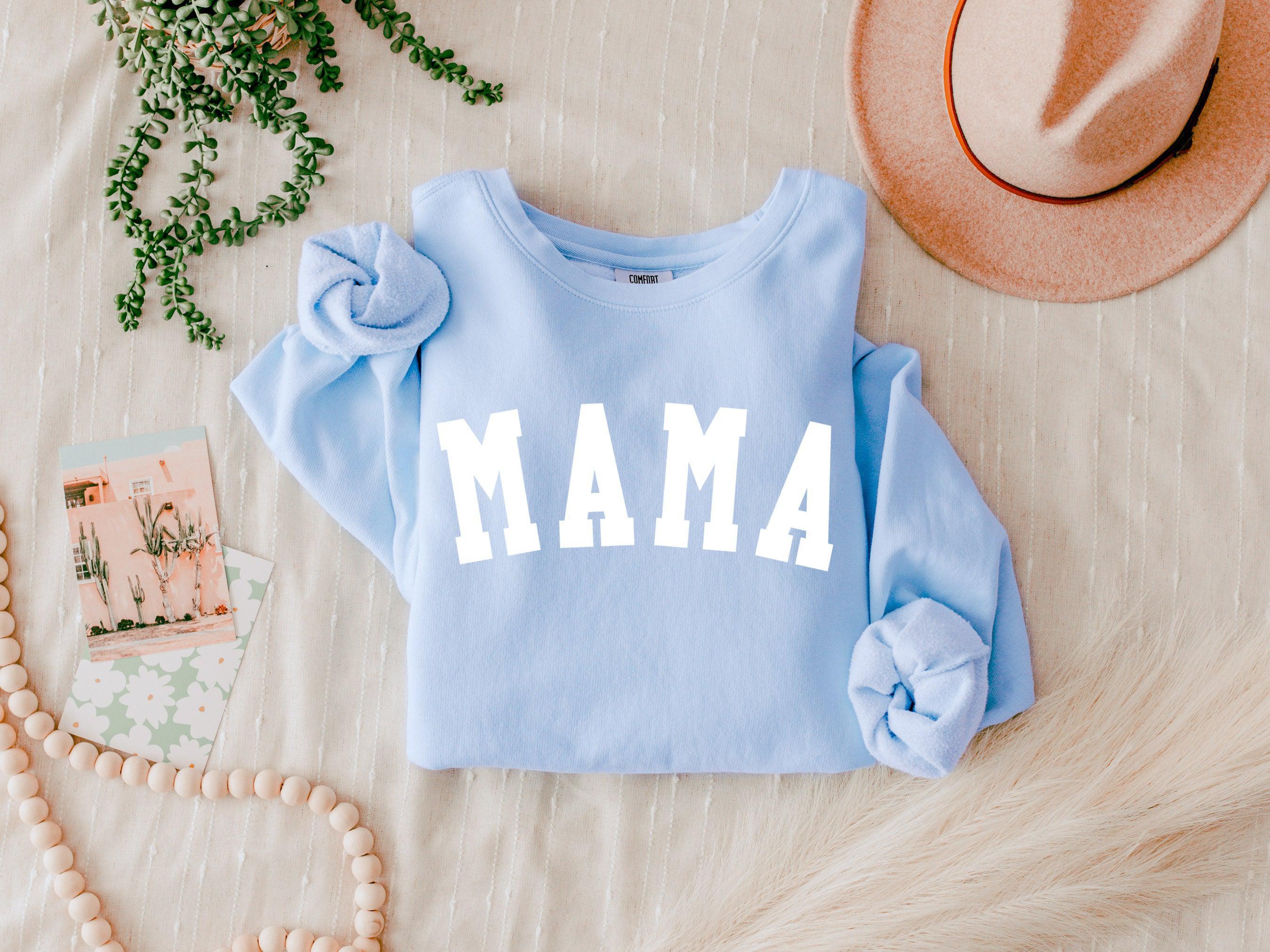Light blue unisex crewneck sweatshirt with large front print reading "MAMA"