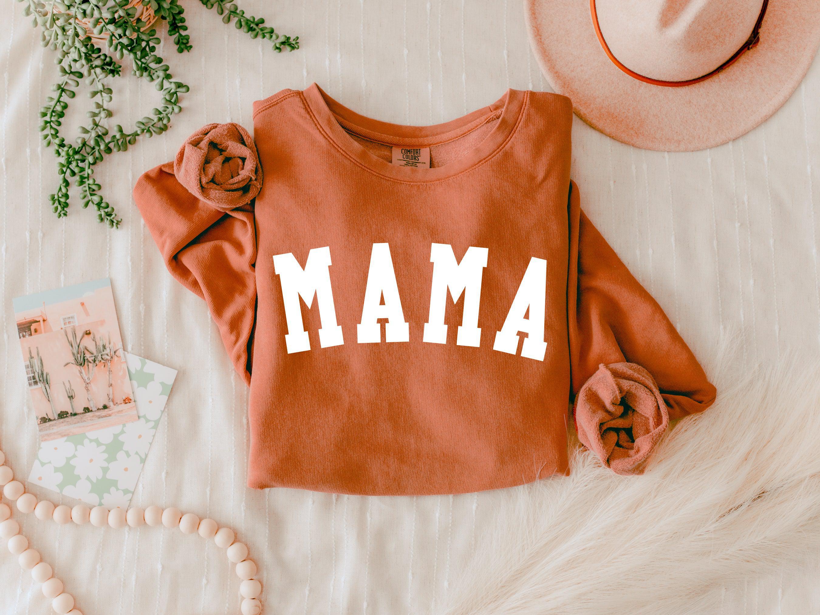 Rust orange MAMA crewneck sweatshirt with long sleeves and white front lettering