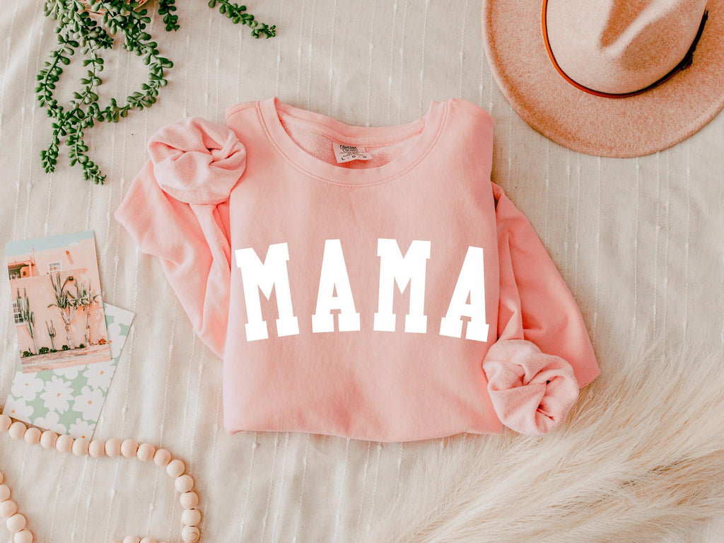 Light pink unisex crewneck sweatshirt with large front print reading "MAMA"