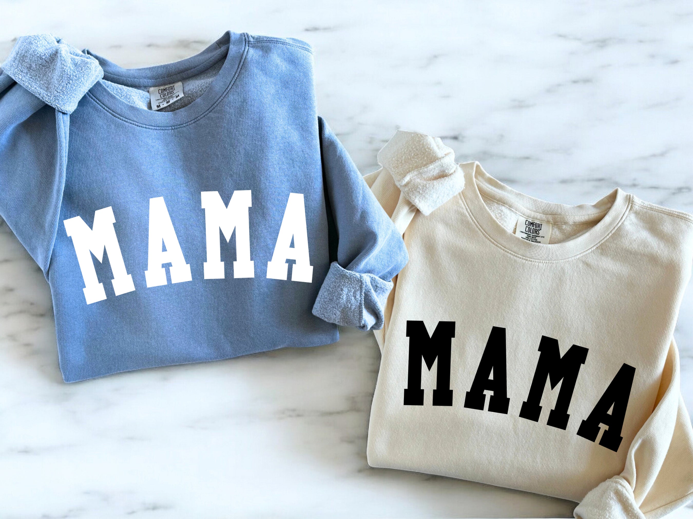 Light blue and cream unisex crewneck sweatshirts, each with front print reading "MAMA"