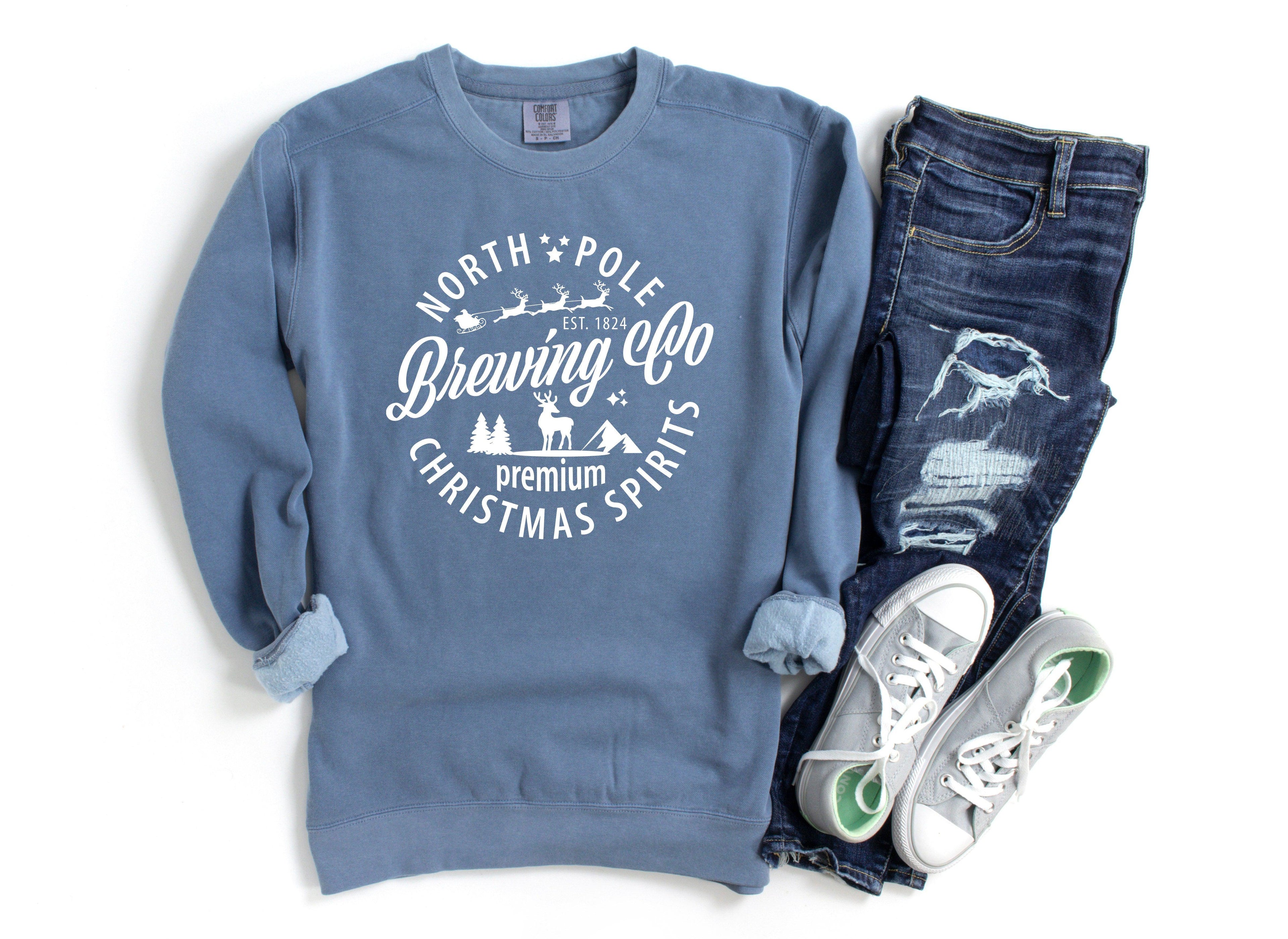 Blue crewneck sweatshirt with holiday logo graphic; ribbed cuffs and hem