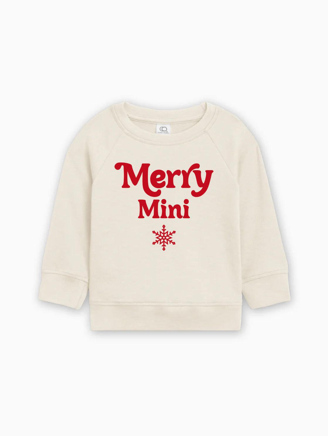 Cream baby pullover sweatshirt with red “Merry Mini” lettering and snowflake graphic