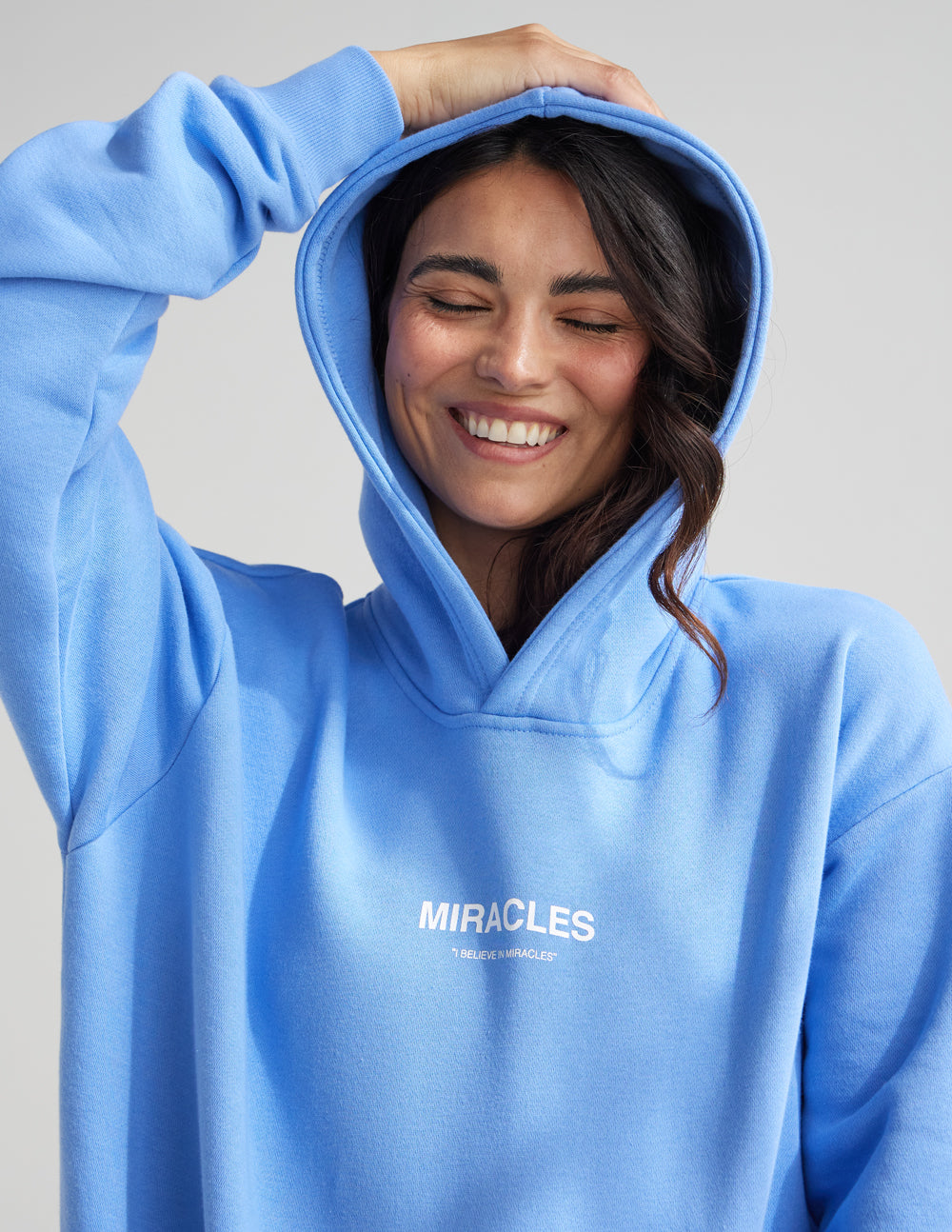 Unisex blue hoodie with hood and MIRACLES chest logo, long sleeves