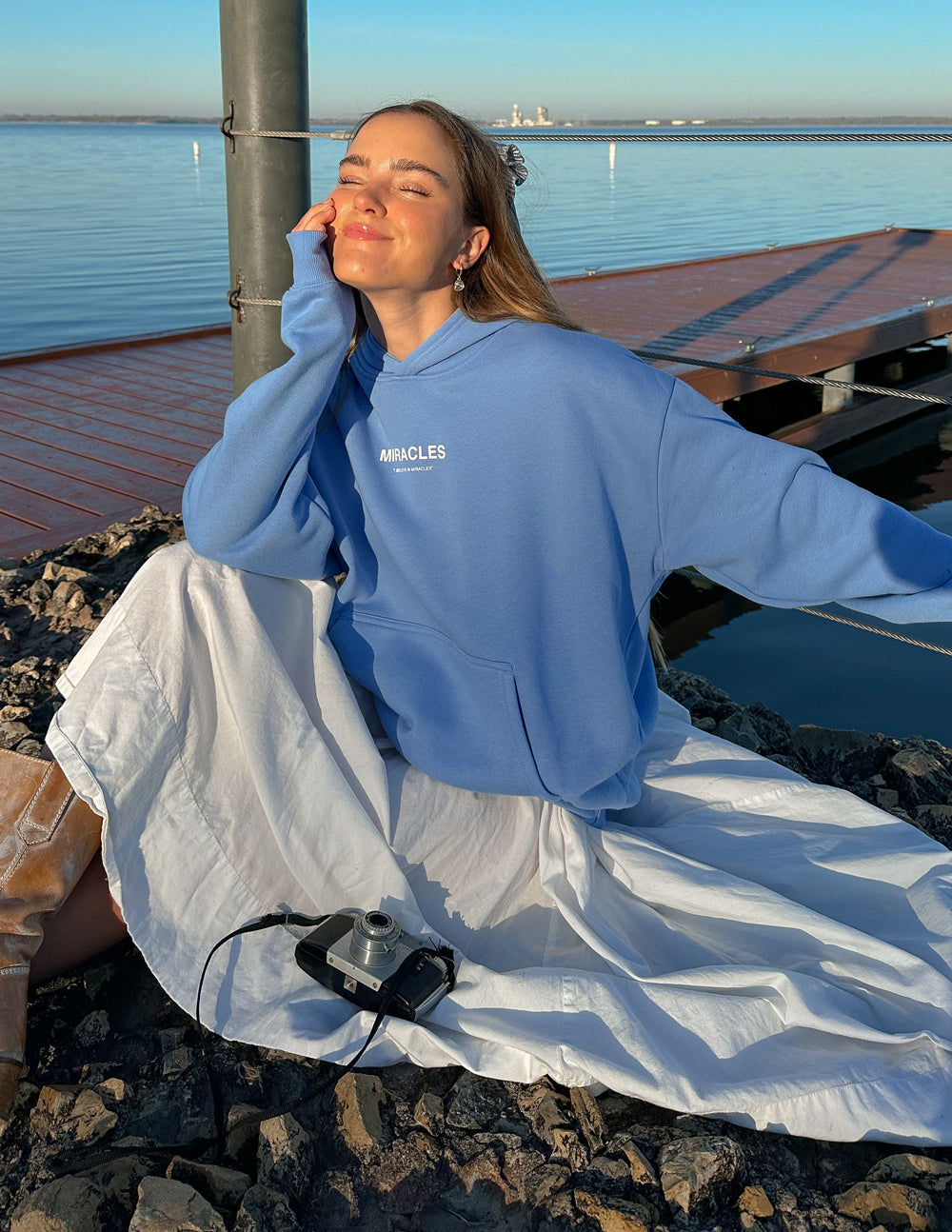 Unisex blue hoodie with hood, MIRACLES logo, and front pouch pocket