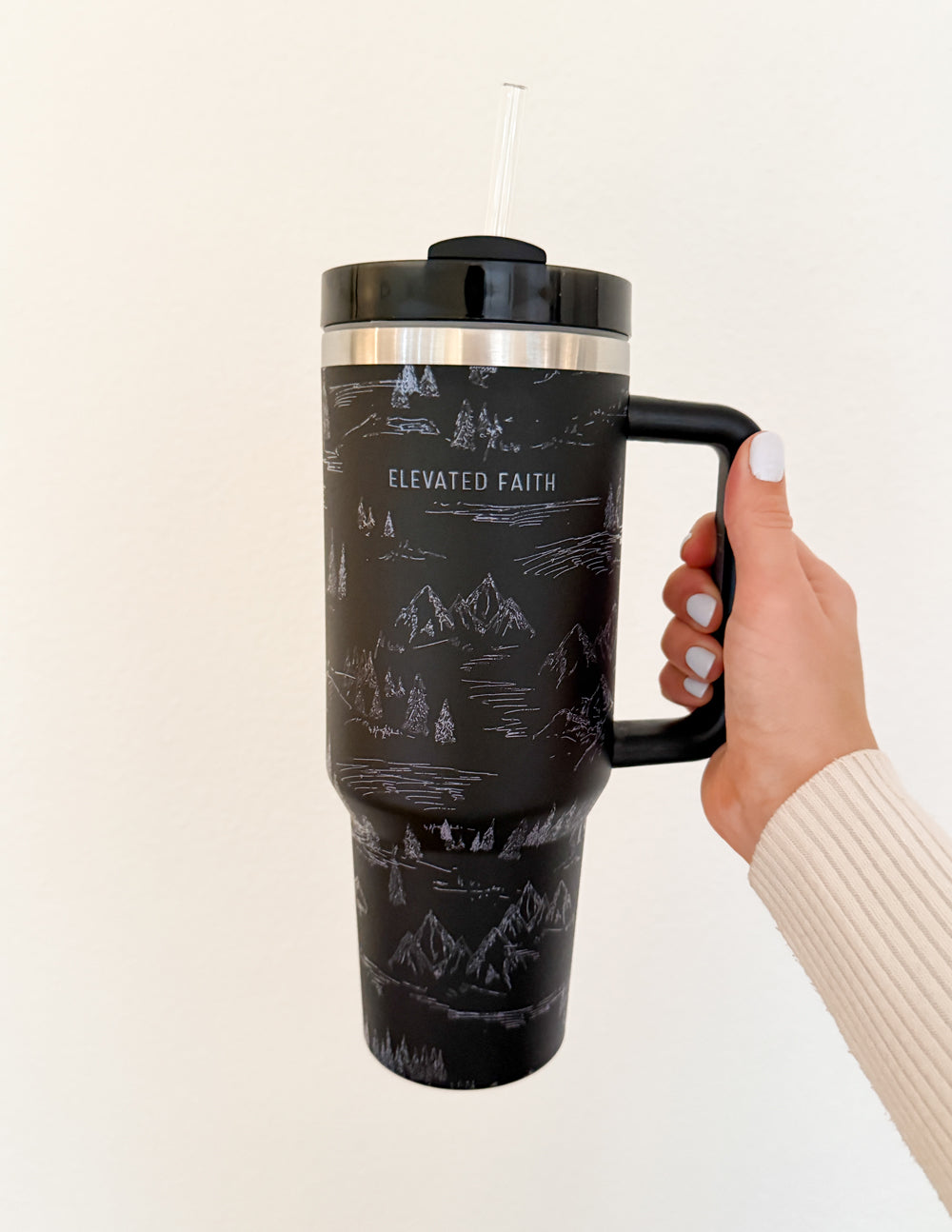 40 oz tumbler, black mountain graphic, black handle with lid and clear straw, hand holding