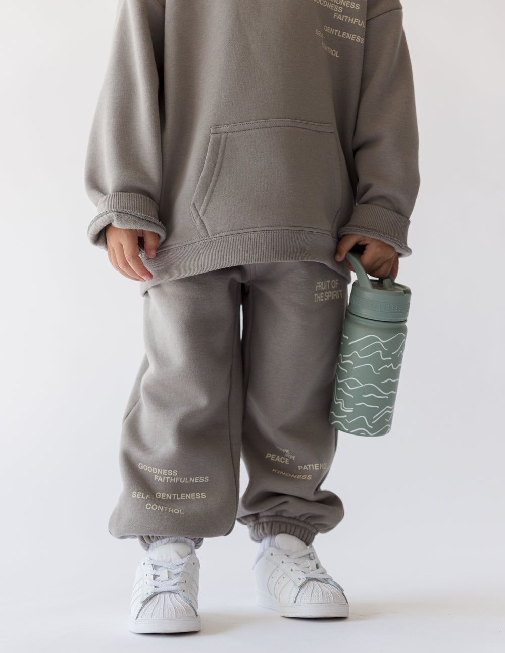 Kids water bottle in sage green with white wave pattern and carry cap