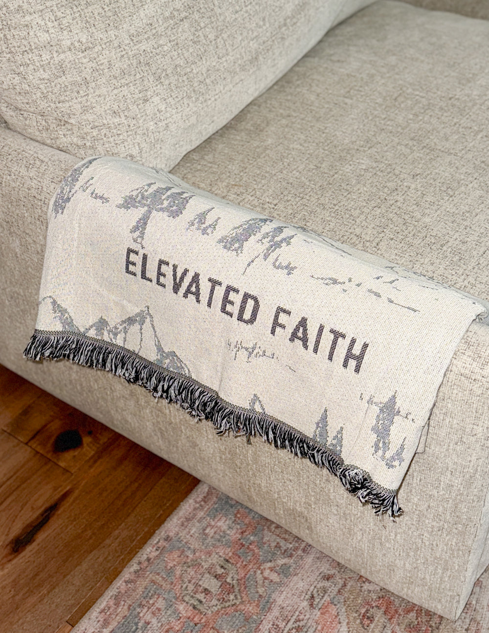 Fringed throw blanket edge with blue mountain scene and “ELEVATED FAITH” text