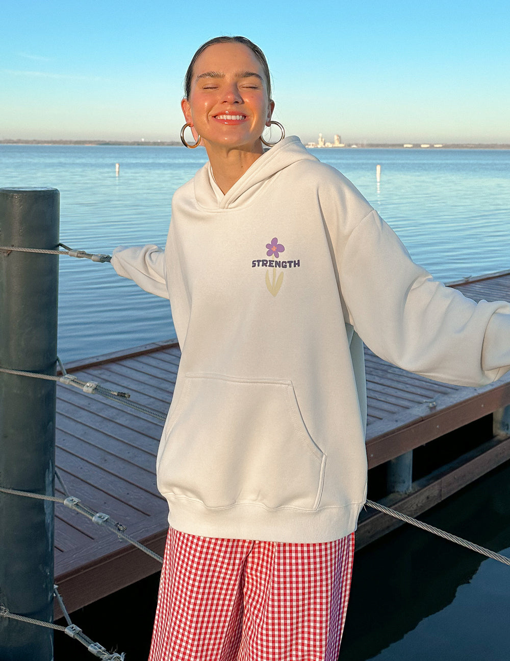 Light-cream unisex hoodie with hood up and Strength logo on chest.