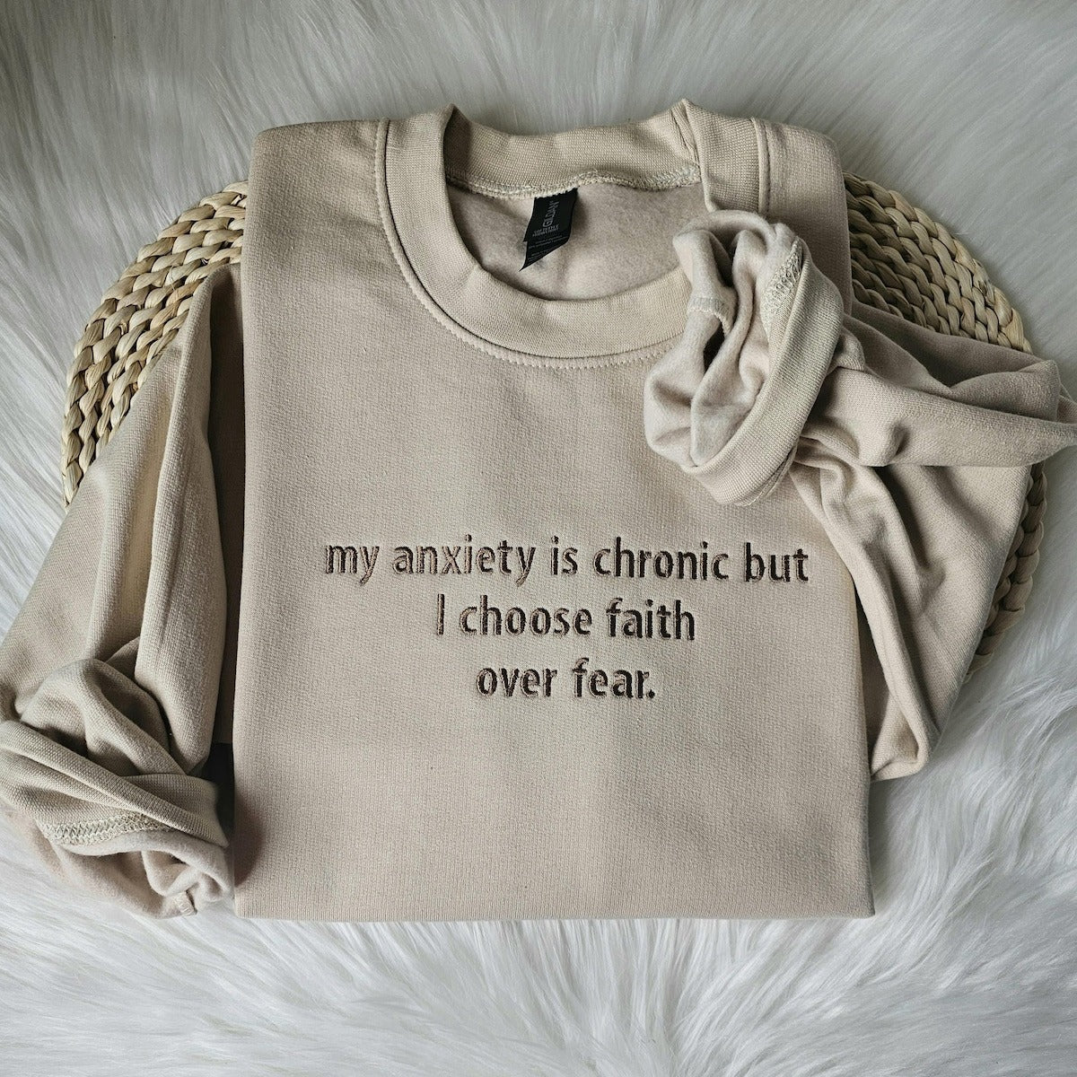 Beige crewneck sweatshirt with embroidered chest message and a folded sleeve