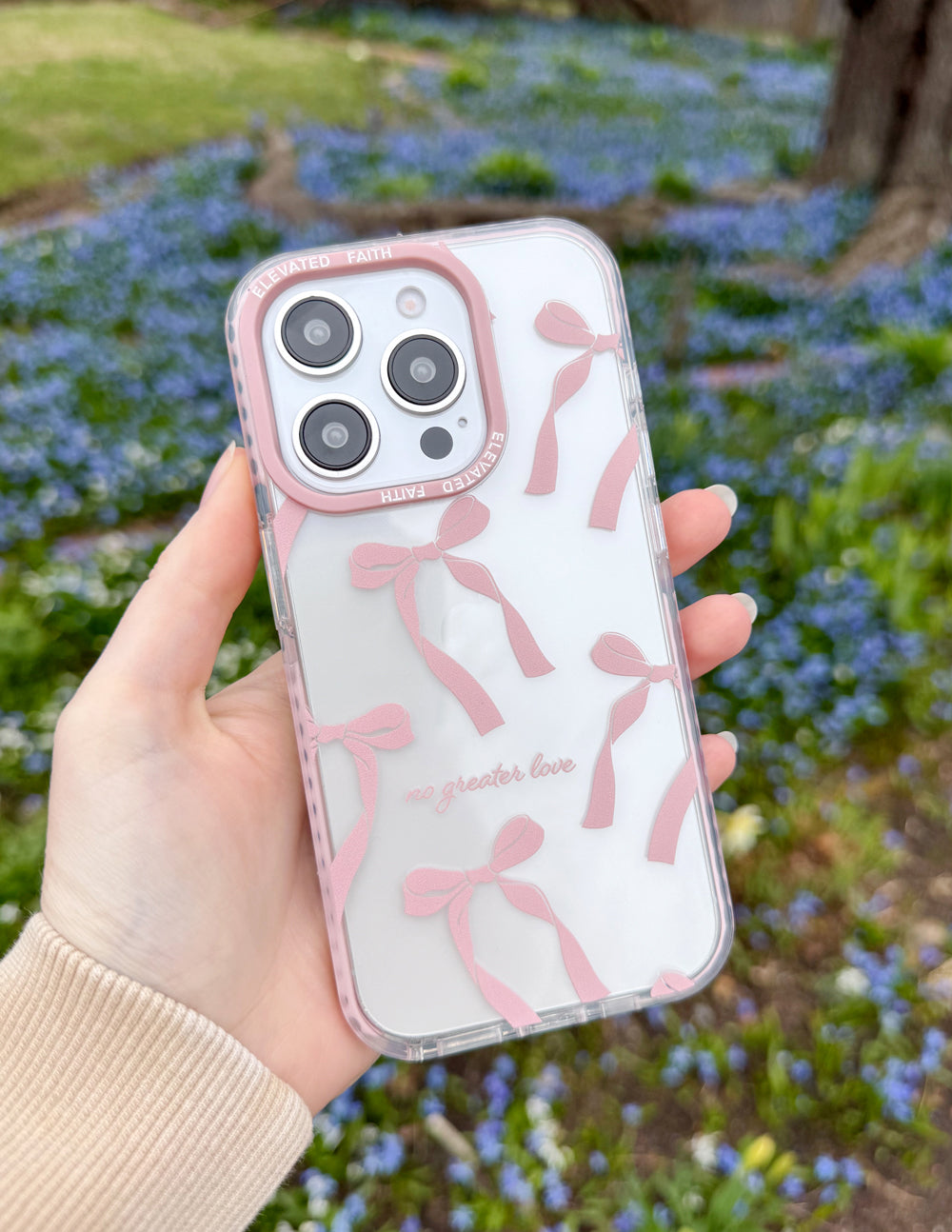 Phone case with pink bow silhouettes on light background, clear frame and camera lenses