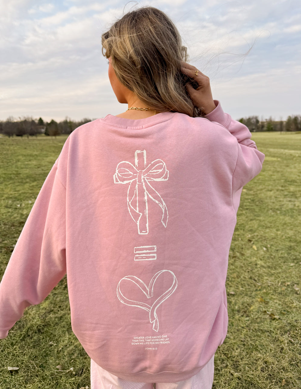Unisex crewneck sweatshirt in pale pink, back graphic bow and heart