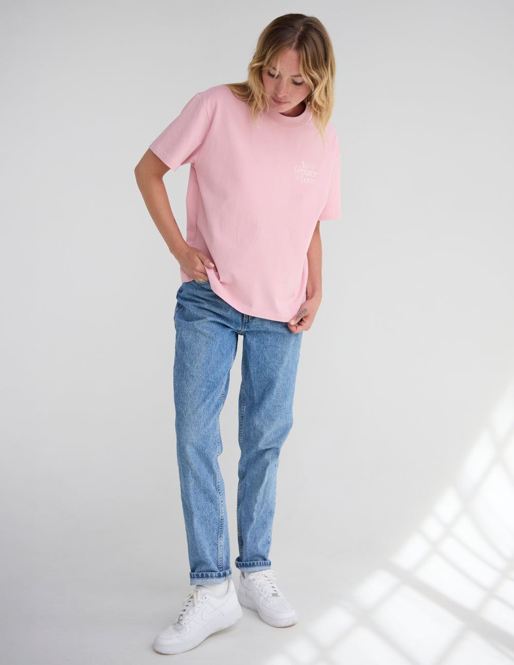 Unisex pink T-shirt with small chest graphic, short sleeves and crew neck.