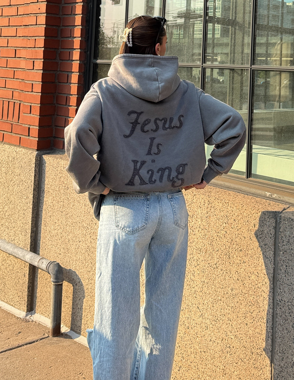 Light gray unisex hoodie with hood and large back script “Jesus Is King” print