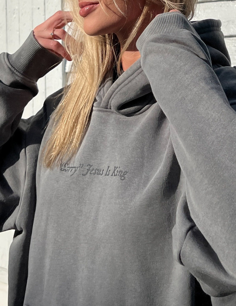 Gray unisex hoodie with hood and small chest script “Jesus Is King” logo