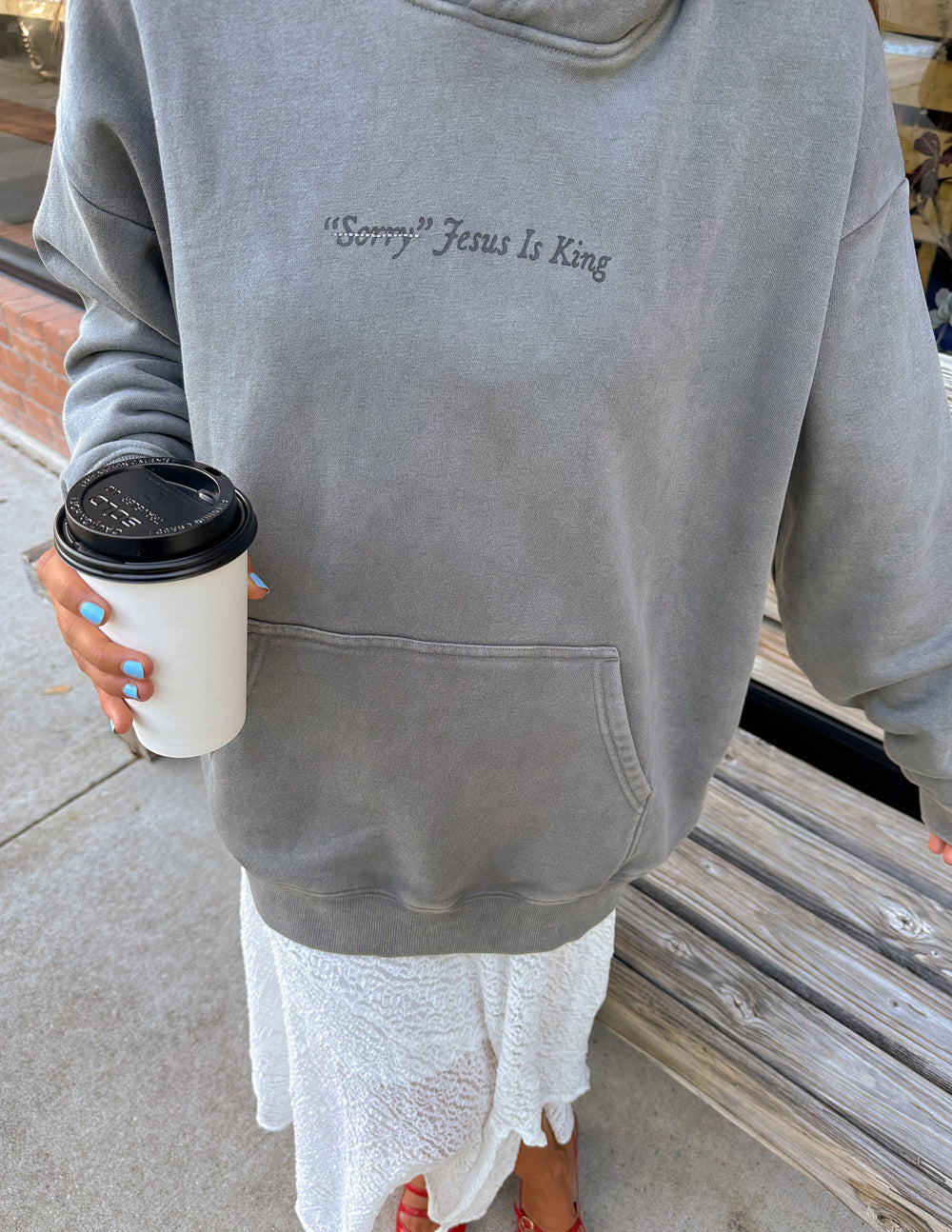 Gray unisex hoodie close-up with chest script text “Jesus Is King”