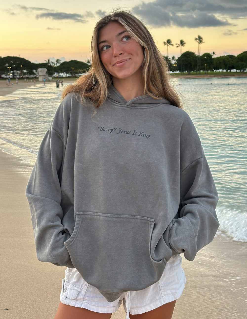 Gray unisex hoodie with hood and front pocket, small script “Jesus Is King” print