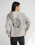 Light beige unisex hoodie, back view with hood and large circular logo graphic