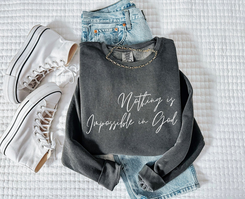 Dark crewneck sweatshirt with long sleeves and white scripture slogan print, flat lay