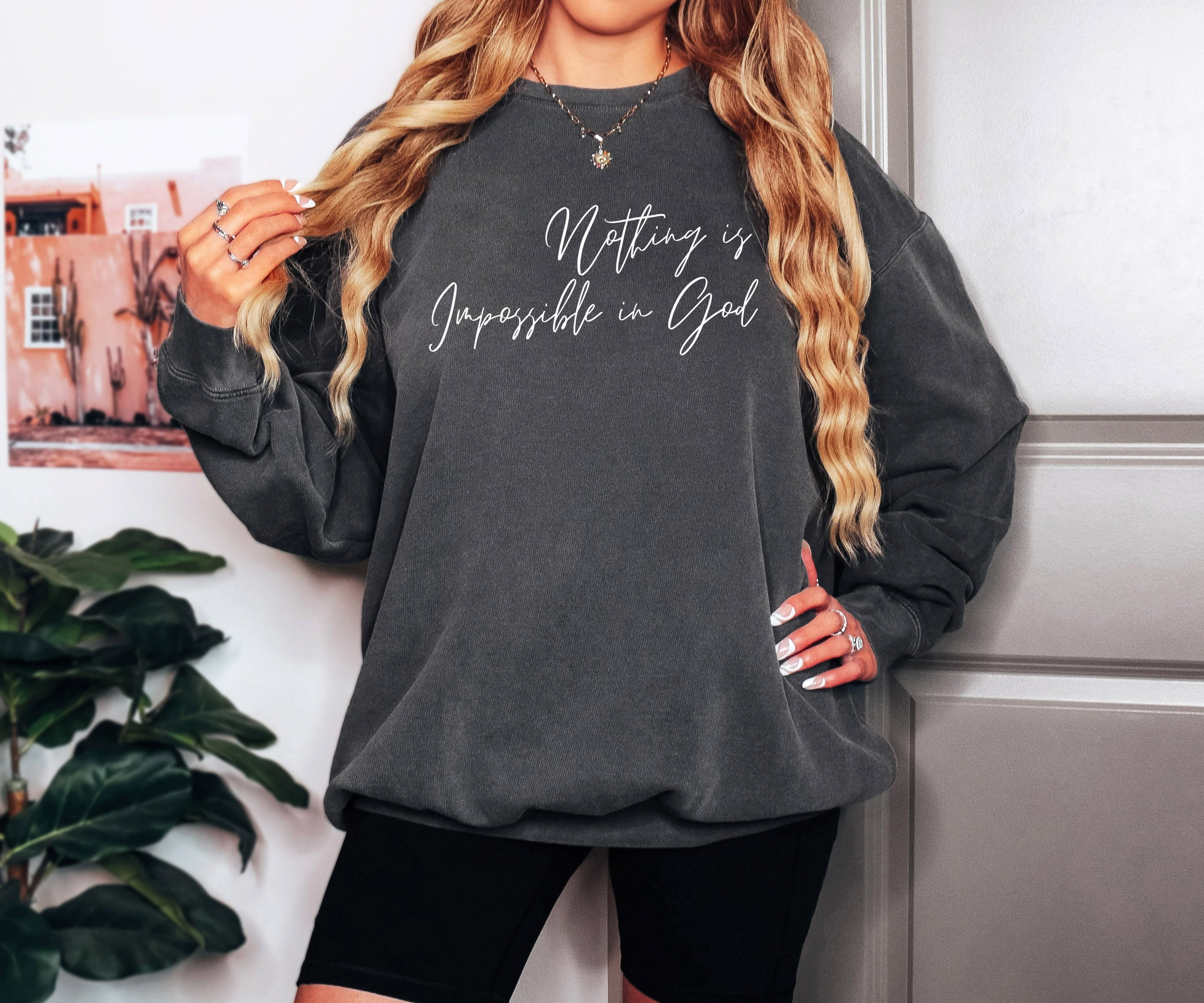 Dark crewneck sweatshirt with long sleeves and white Christian-style slogan print