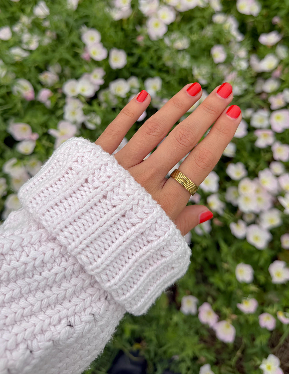 Gold tone ribbed band ring on finger with striped texture