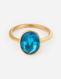 Gold gemstone ring with oval blue stone, raised bezel