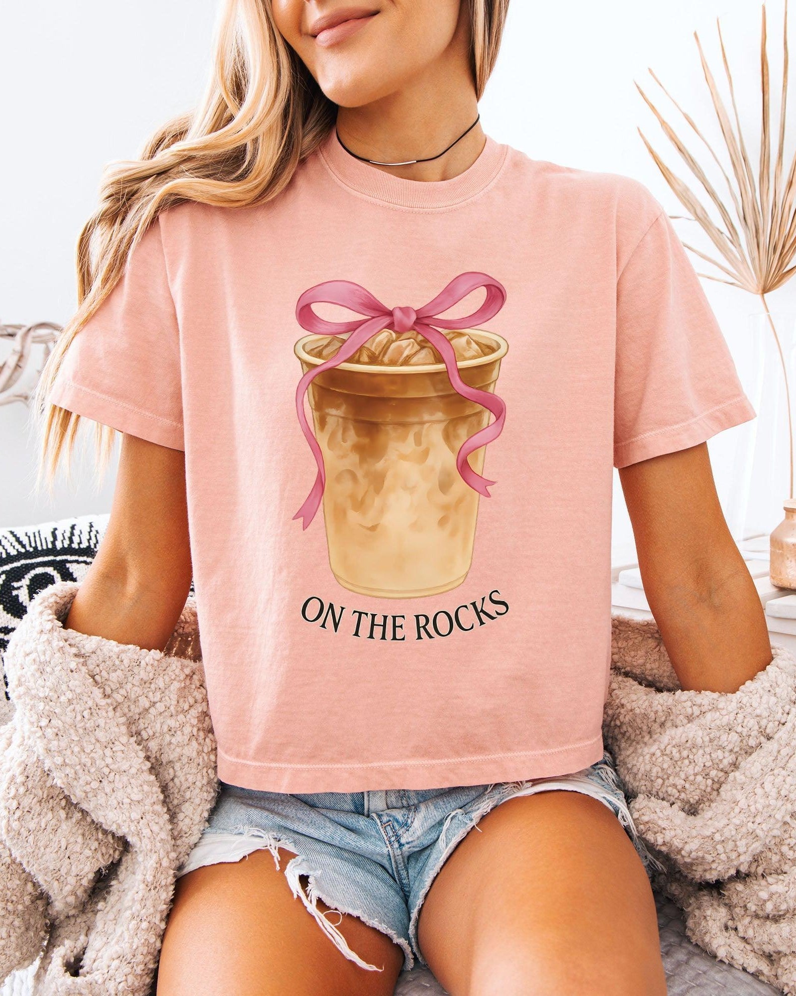 Women’s cropped T-shirt, dusty pink with pink bow latte graphic and 'ON THE ROCKS'.