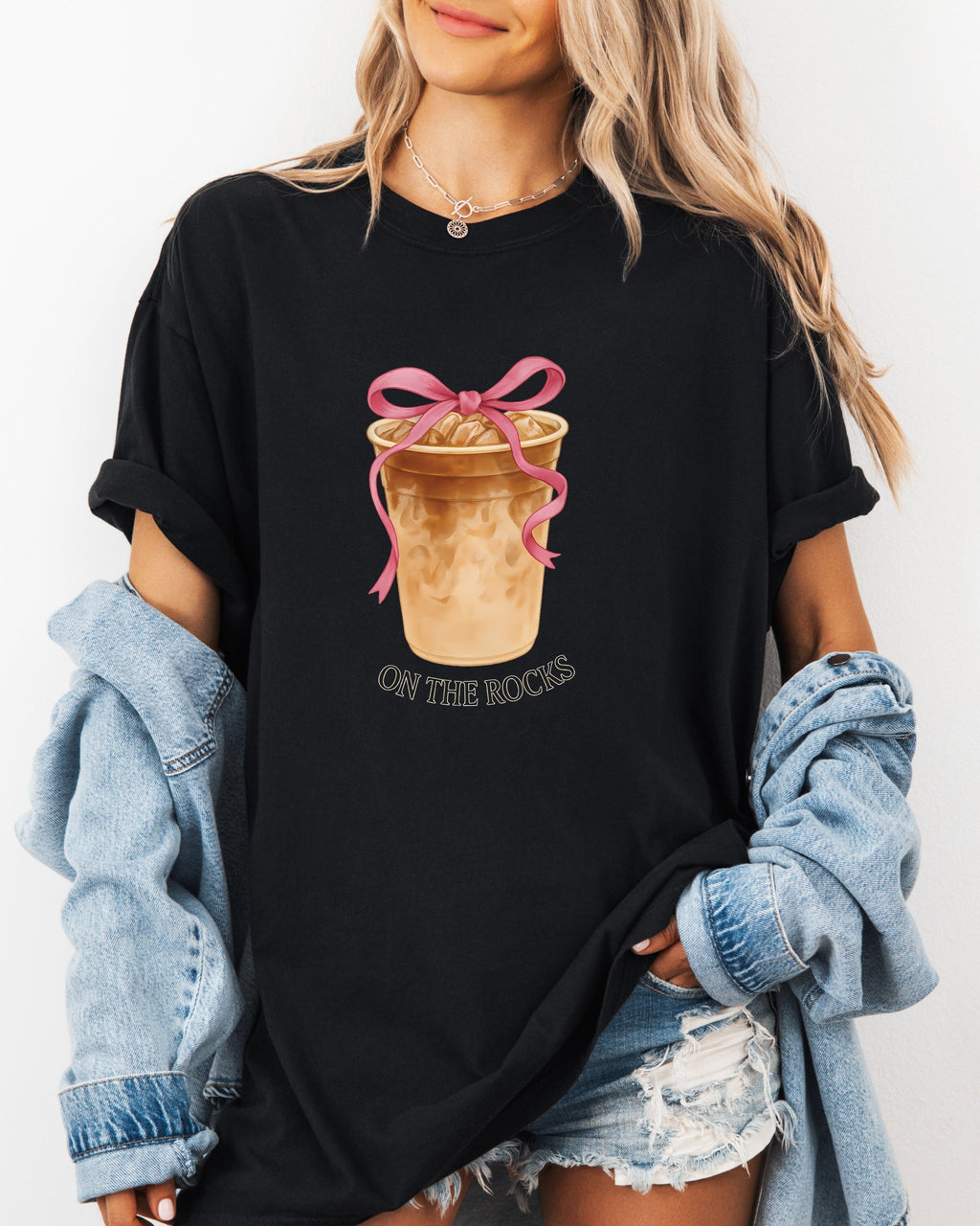 Black iced latte graphic T-shirt with ribboned cup and small “ON THE ROCKS”