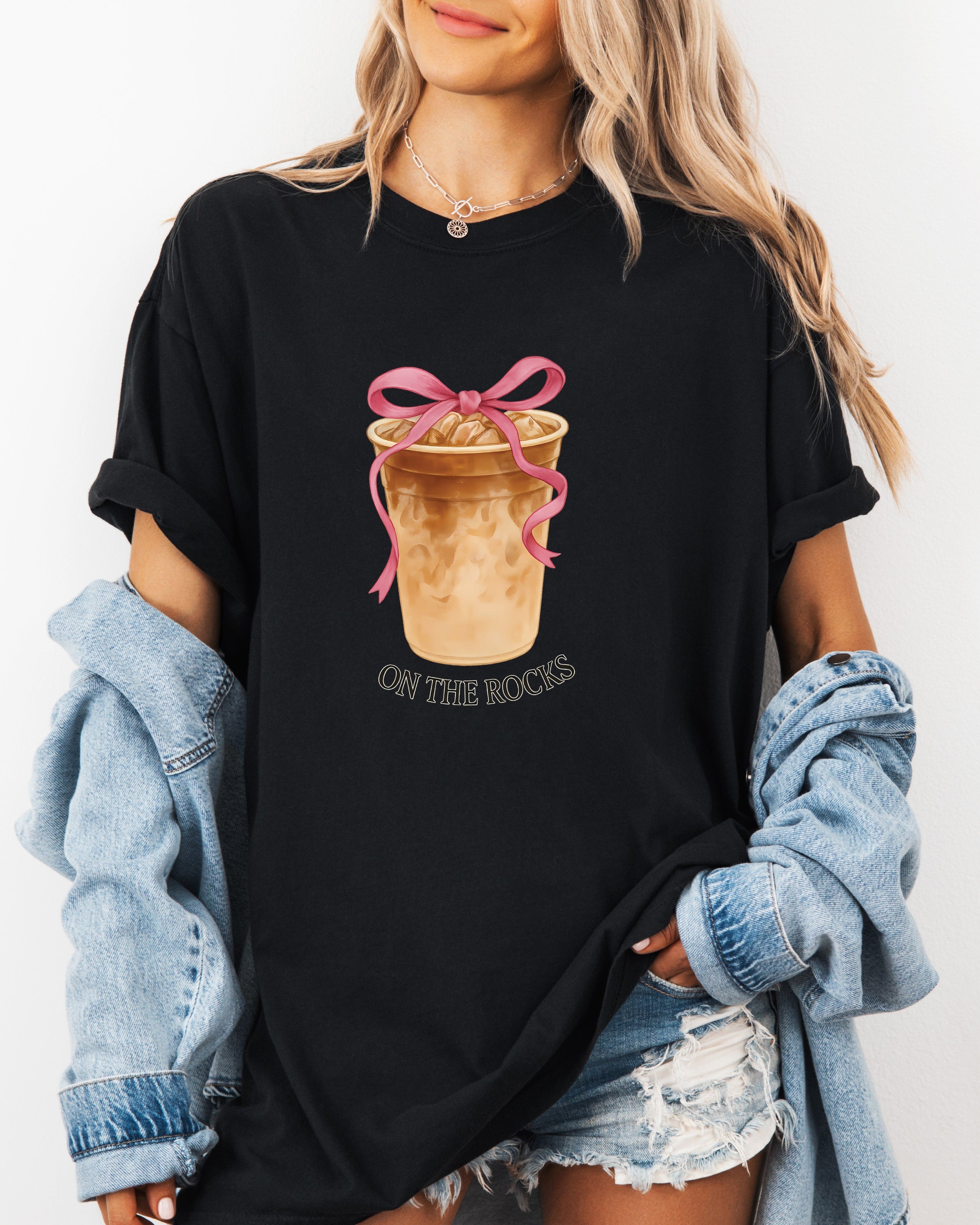 Black iced latte graphic T-shirt with ribboned cup and small “ON THE ROCKS”