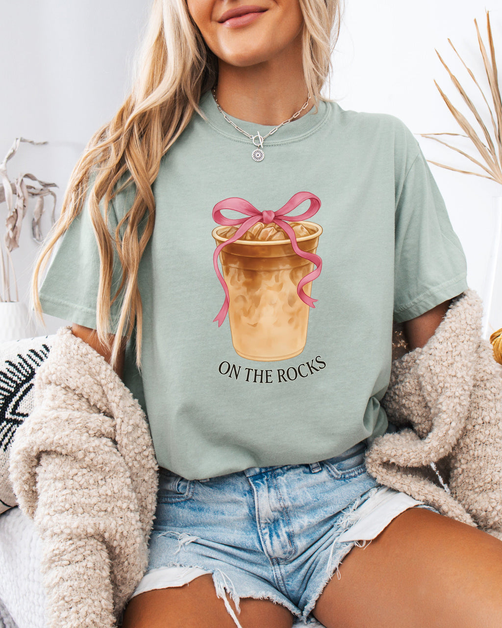 Green iced latte graphic T-shirt with ribboned cup and “ON THE ROCKS” text