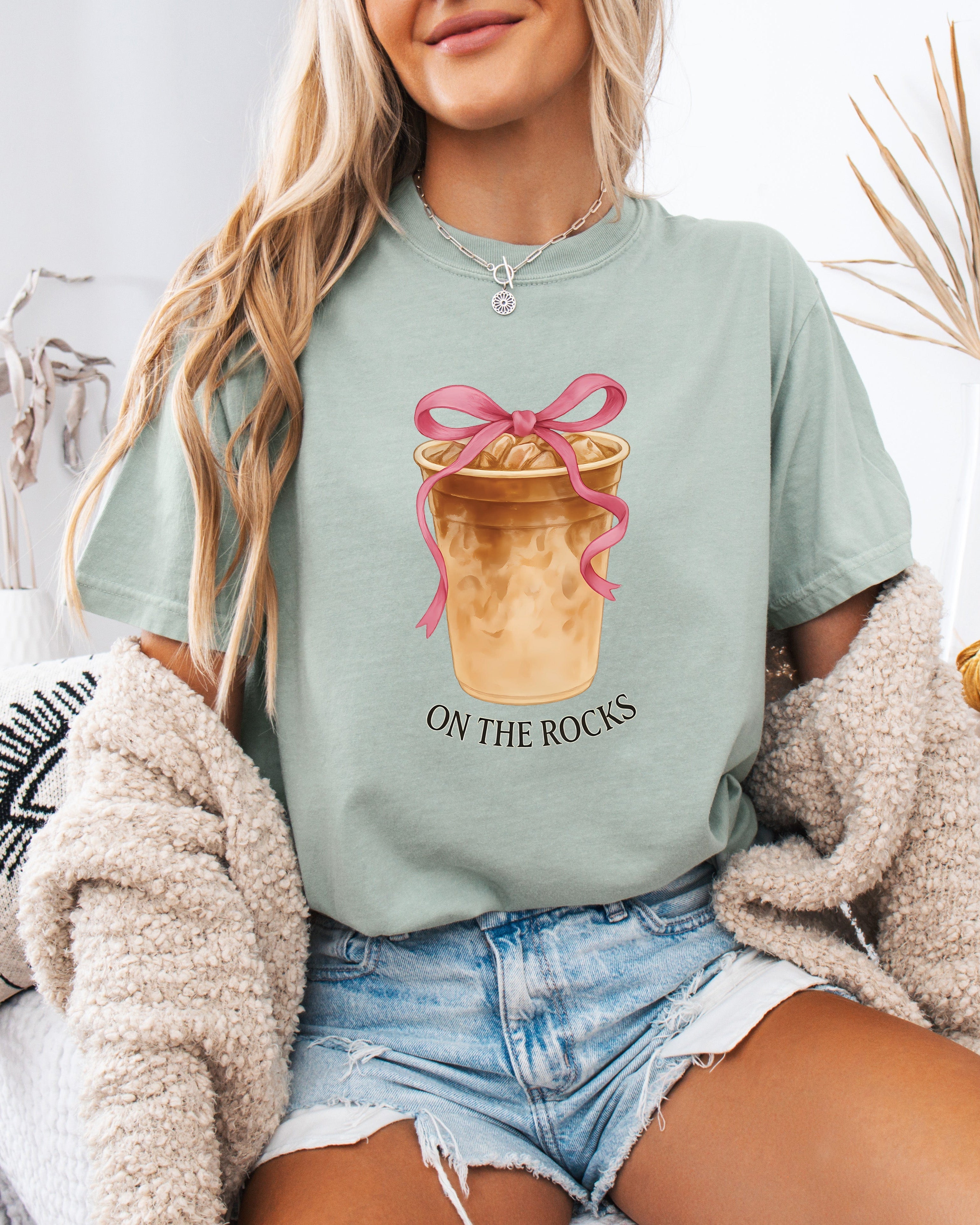 Green iced latte graphic T-shirt with ribboned cup and “ON THE ROCKS” text