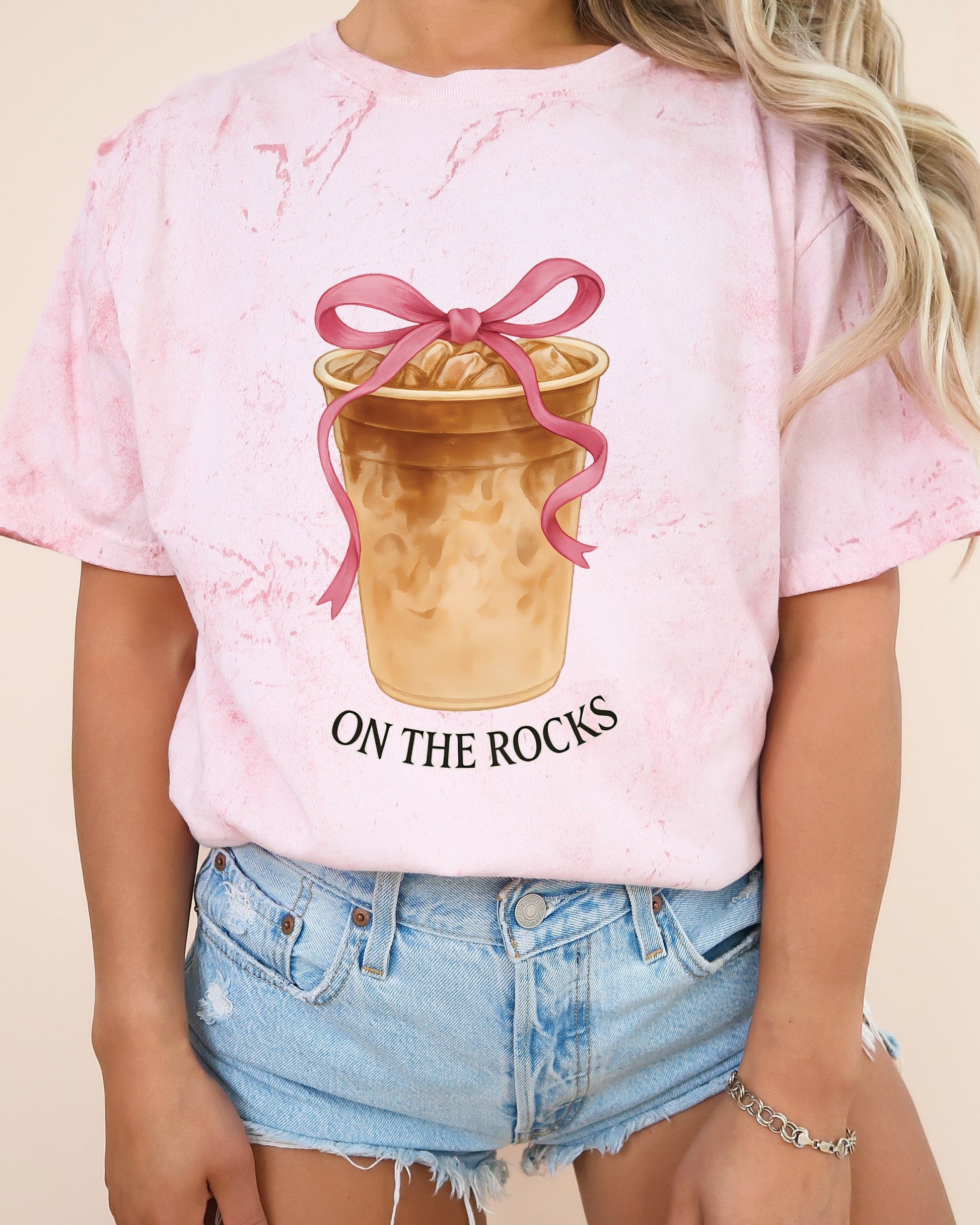 Light pink iced latte graphic T-shirt with ribboned cup and “ON THE ROCKS”