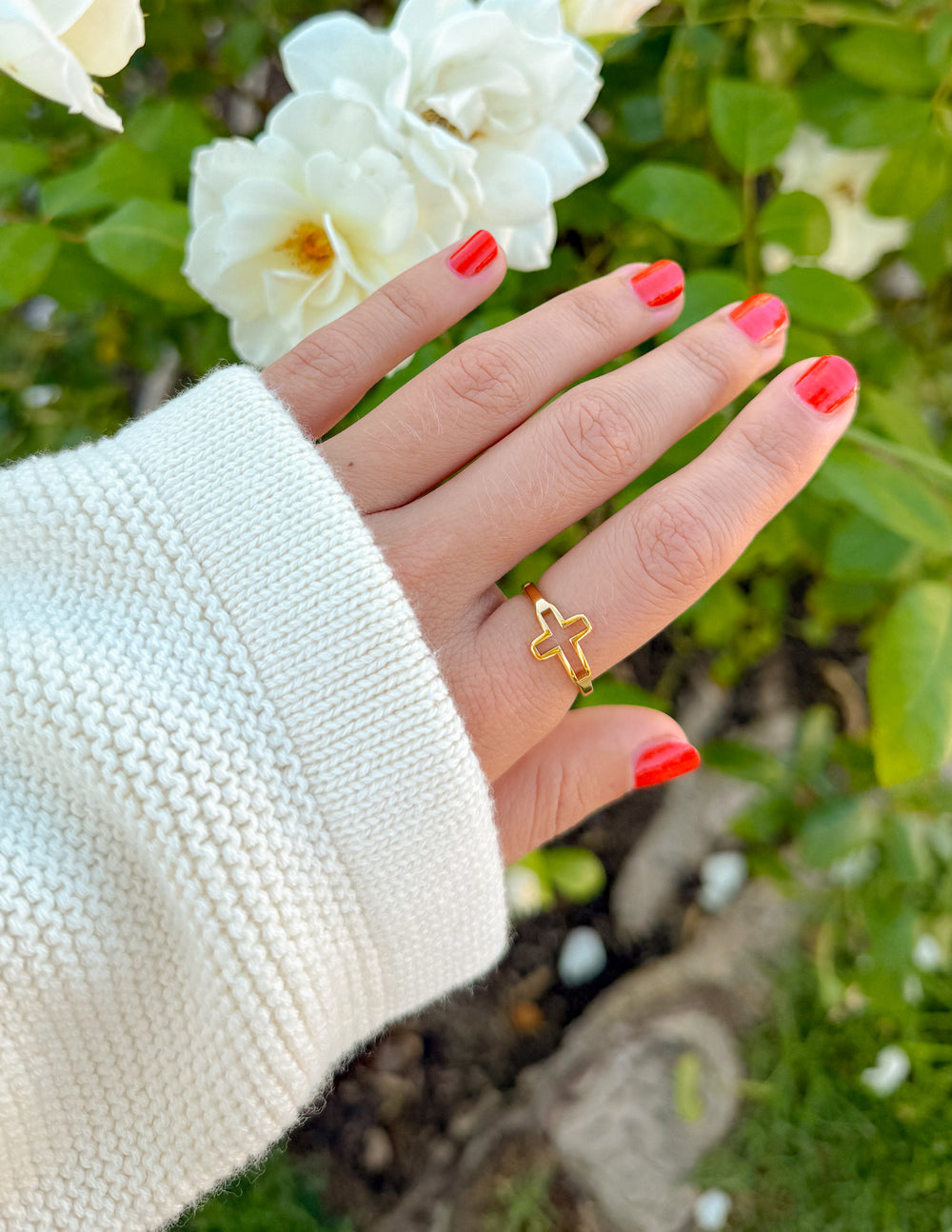 Gold-tone cross open ring with cross charm on finger