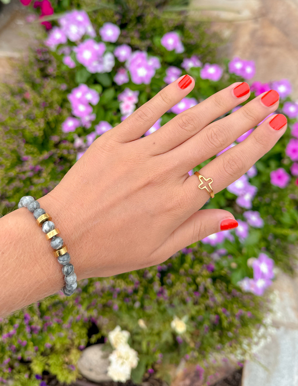 Gold-tone open cross ring on finger, cross centerpiece visible