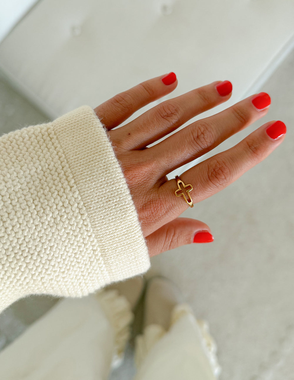 Gold-tone open cross ring on finger, cross motif with open band