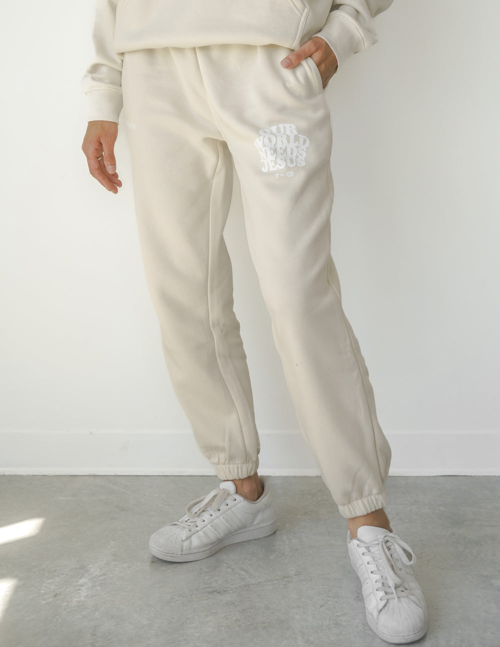 Beige unisex sweatpants with logo print on thigh and elastic ankle cuffs