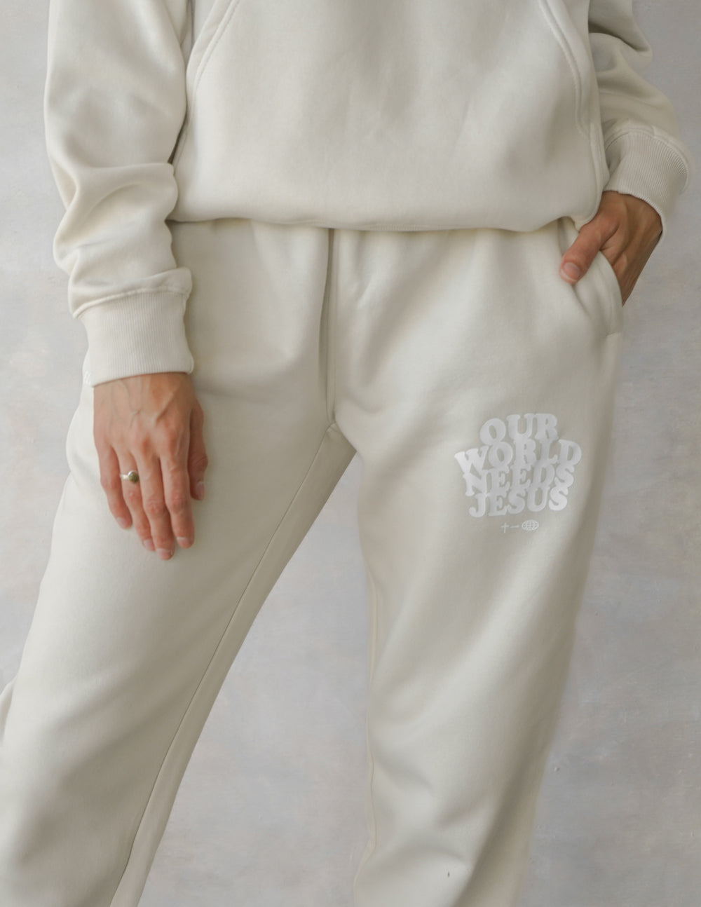 Beige unisex sweatpants with logo print on leg, relaxed straight leg silhouette