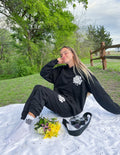 Black unisex sweatpants with elastic waist and white logo print on legs