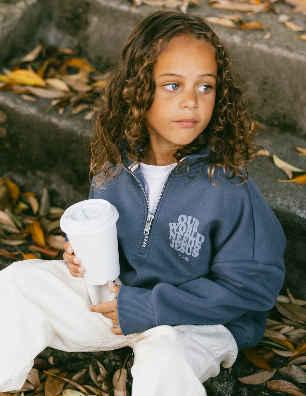 Kids half-zip sweatshirt in dark blue with front logo, worn with long sleeves