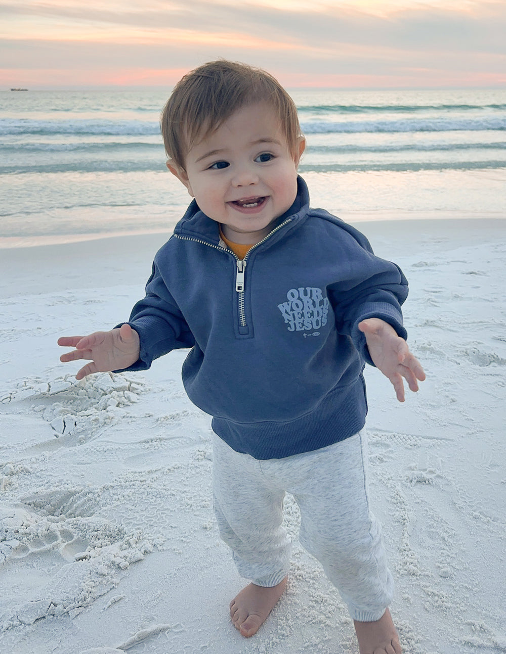 Kids half-zip sweatshirt in dark blue with front logo, child standing outdoors