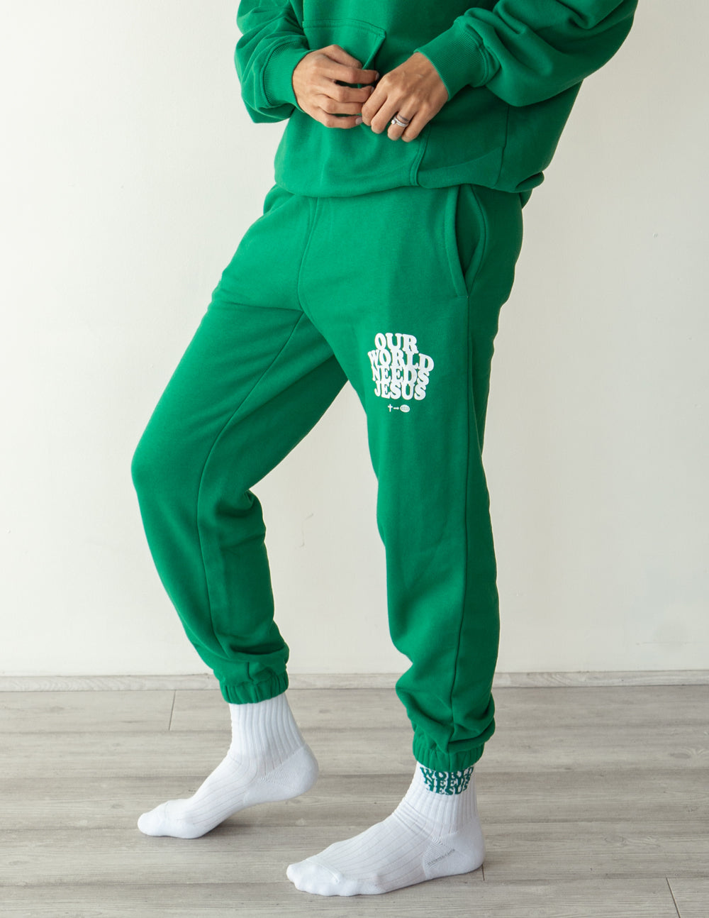 Green unisex sweatpants with logo print on right thigh and elastic cuffs