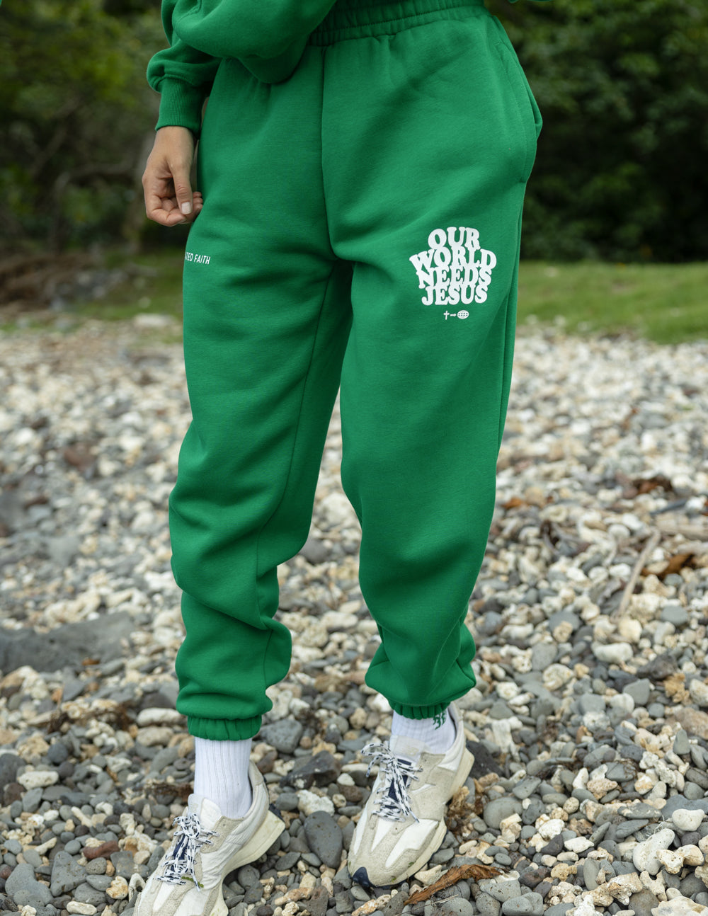 Green unisex sweatpants with logo patch on left leg and gathered cuffs