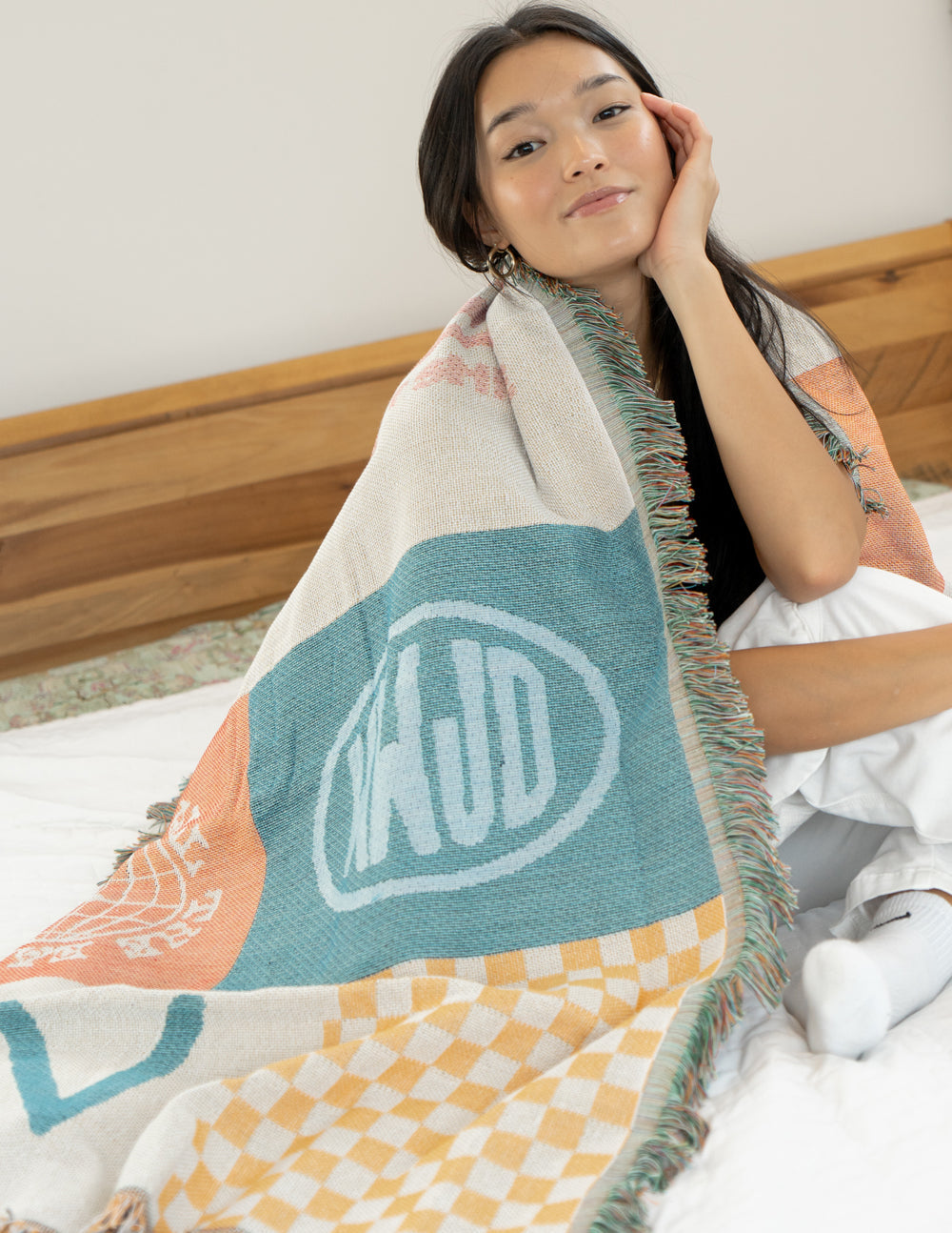 Patchwork throw blanket with large teal icon print on cream, pastel orange section, fringe