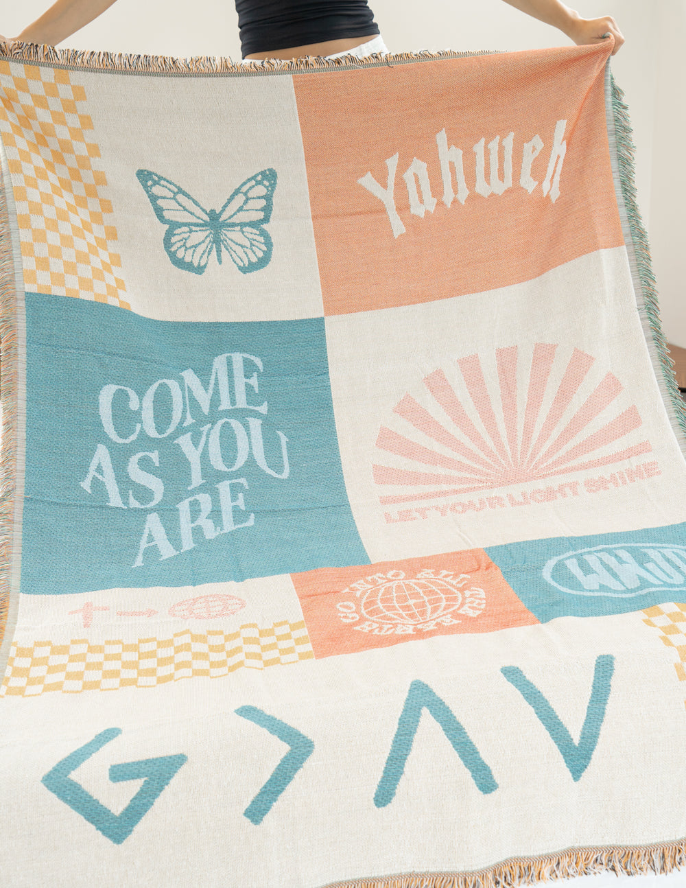 Patchwork throw blanket close-up with butterfly and sunburst graphics, “Yahweh” text, fringe