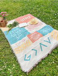 Patchwork throw blanket with pastel orange, teal, and cream blocks, fringed edges