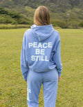 Light blue unisex hoodie with hood and “PEACE BE STILL” back graphic print