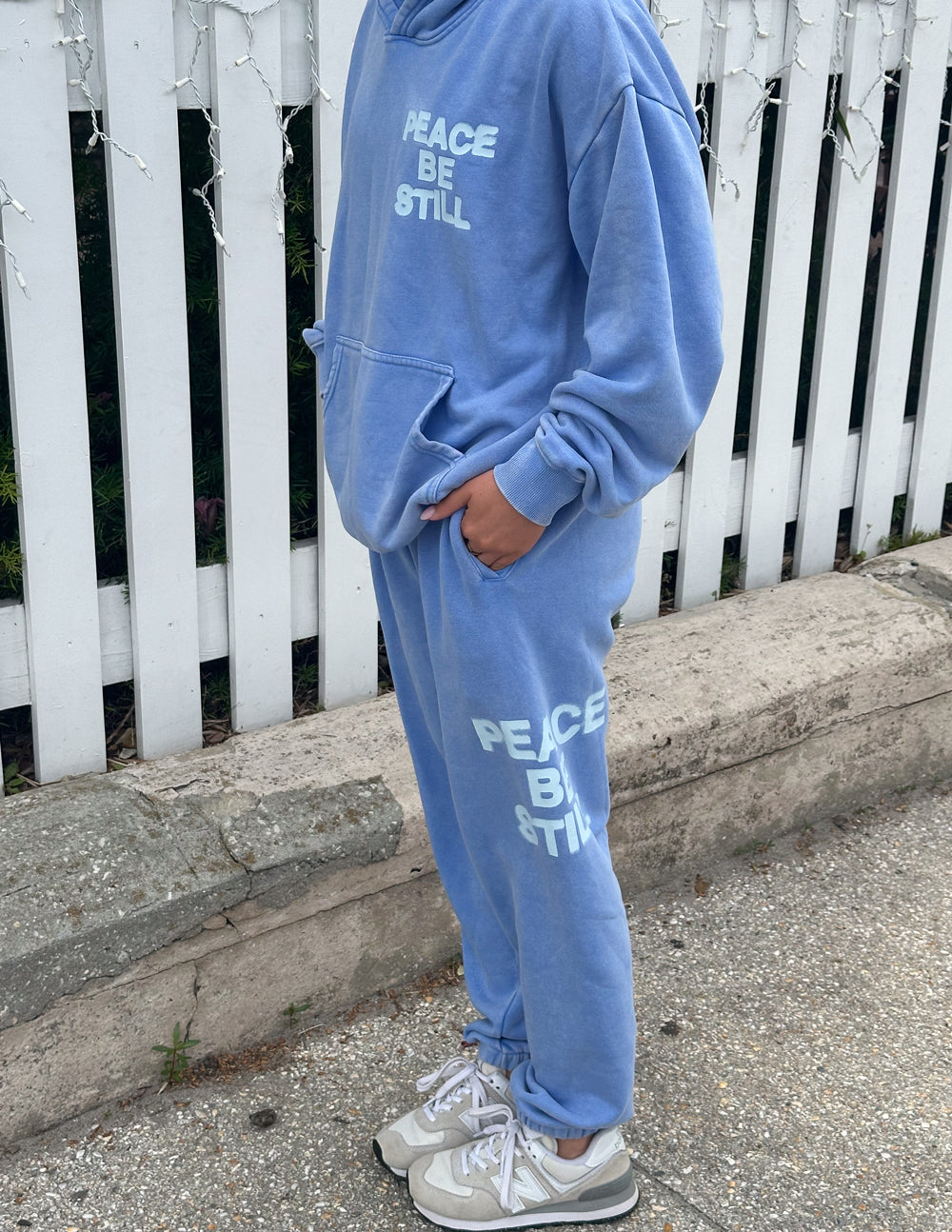 Light blue unisex sweatpants with “PEACE BE STILL” graphic and jogger-style cuffs
