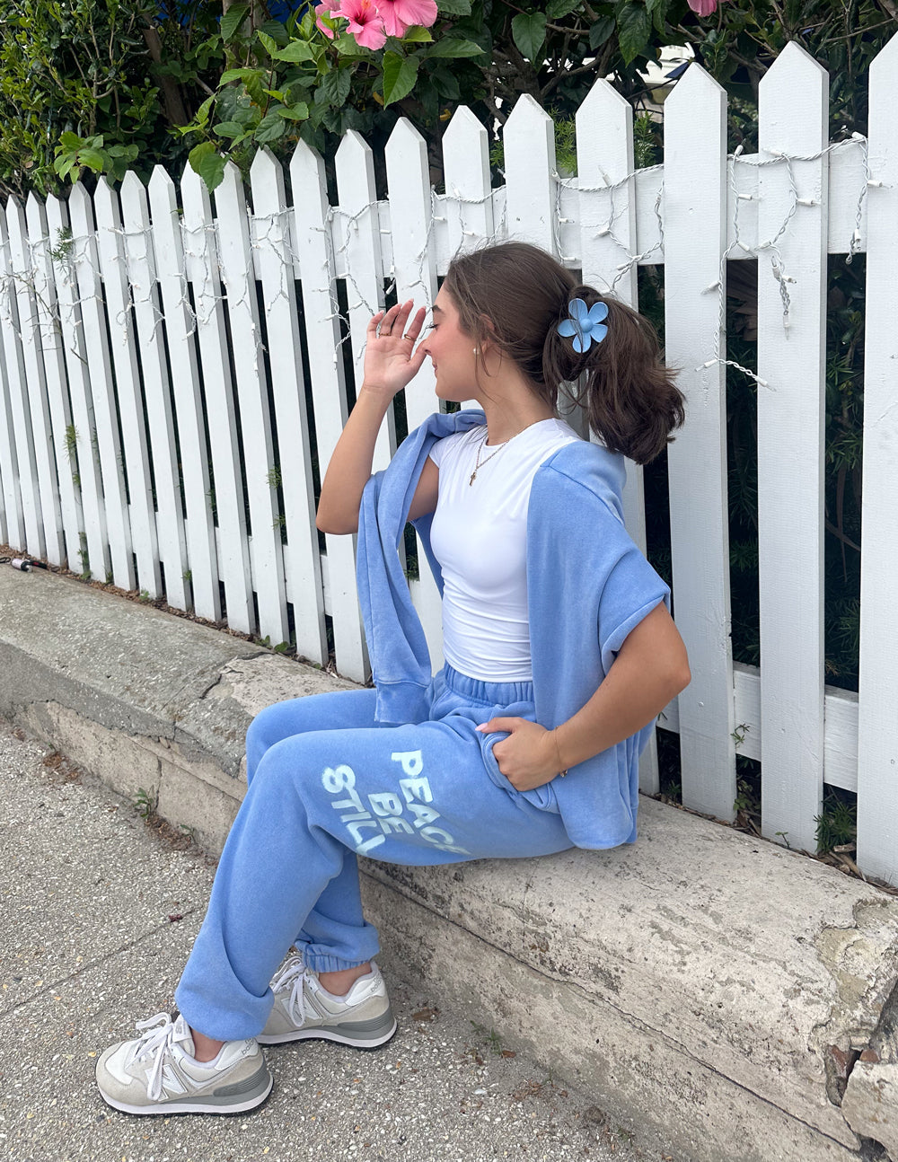 Light blue sweatpants with “PEACE BE STILL” printed at the thigh