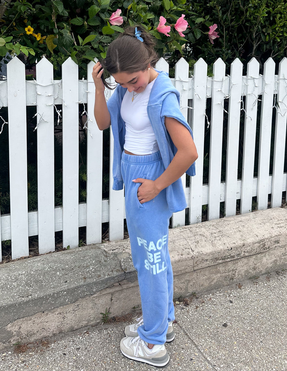 Light blue unisex sweatpants with “PEACE BE STILL” graphic on the leg near the ankle