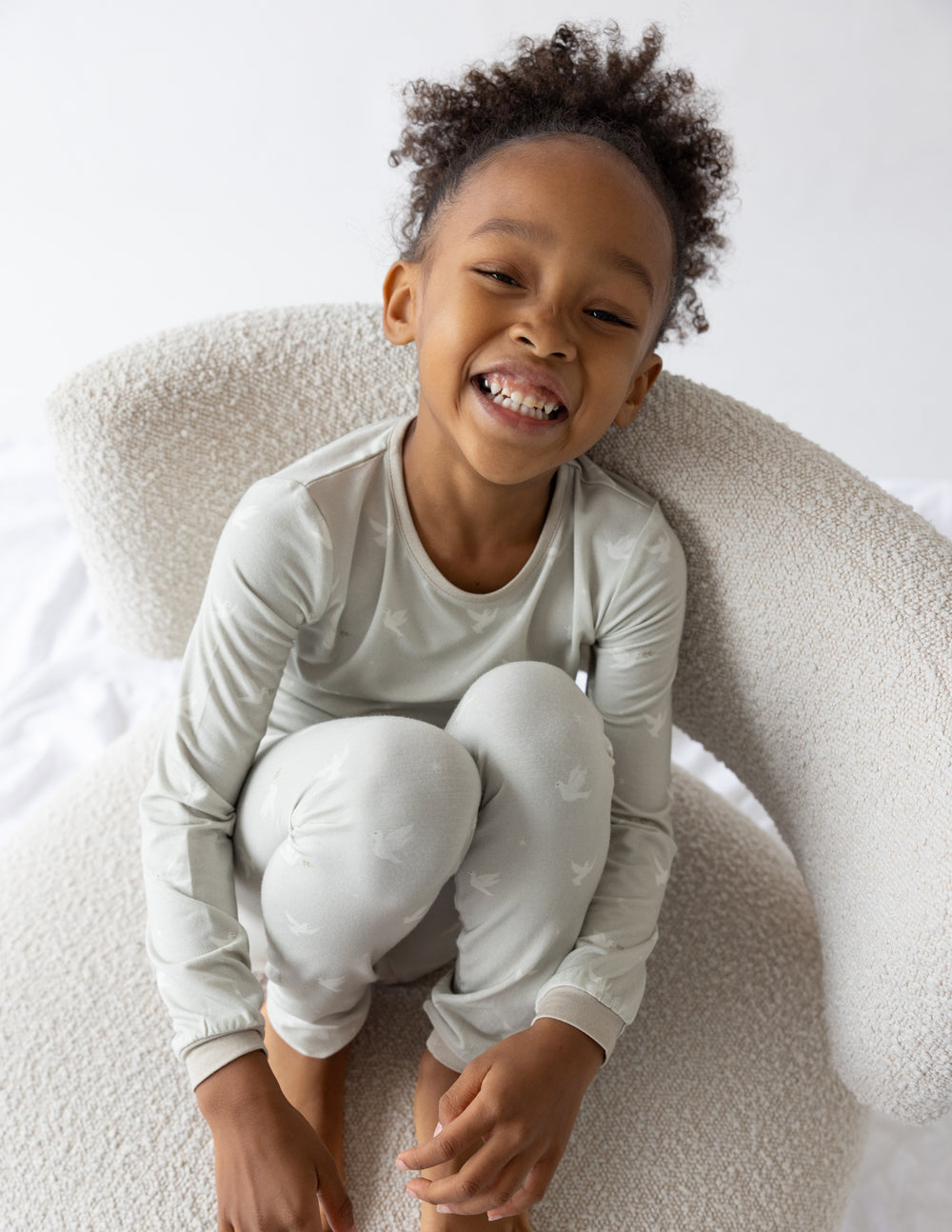 Kids bamboo pajama set on child: long-sleeve top and ankle jogger pants, light cream