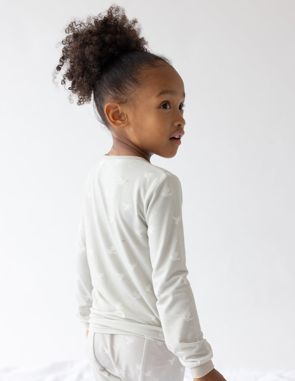 Kids bamboo pajama set back view: long-sleeve top and jogger pants, light cream print
